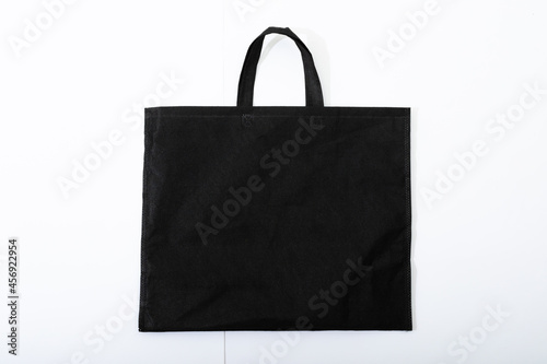 Composition of empty black canvas shopping bag lying flat on white background