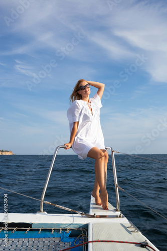 young woman drinking champagne on a yacht in the open sea © Aleksandra Iarosh