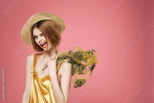 woman in hat with bouquet of flowers decoration luxury pink background