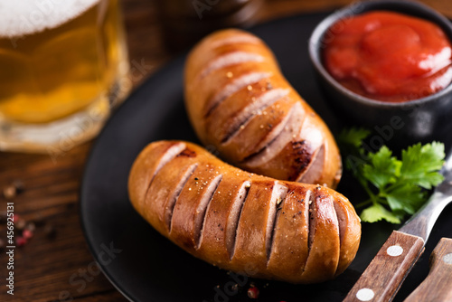 German Grilled Sausages With Tomato Sauce And Beer On Background. Octoberfest Food Concept
