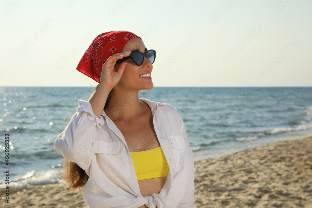 Young woman with sunglasses and bandana at beach. Sun protection care Young woman with sunglasses and bandana at beach. Sun protection care