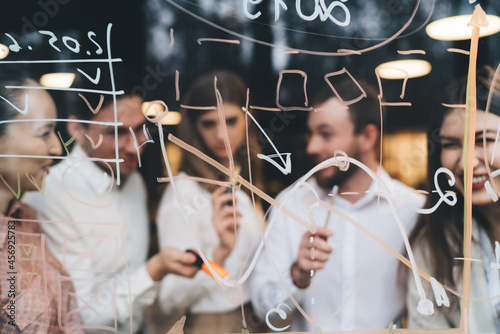 Group of colleagues writing goals in office