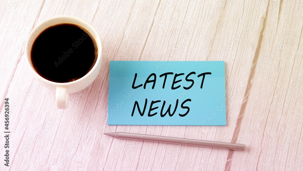 LATEST NEWS text on the blue sticker with cofee and pen