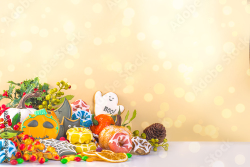 Happy Halloween greeting card background. Trick or treat concept. Traditional gingerbread cookies  candy  sweets  pumpkins  decorations with bokeh lights effect