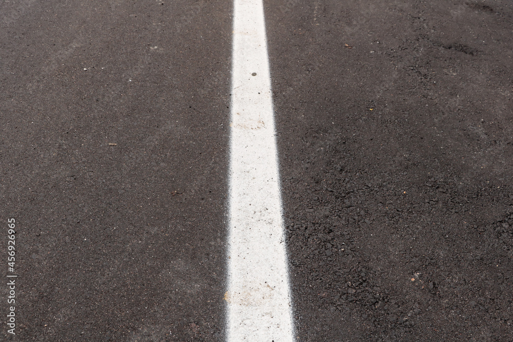 Asphalt track just made with some dirt and its texture, with a white strip painted in the center of the image Asphalt track just made with some dirt and its texture, with a white strip painted in the center of the image