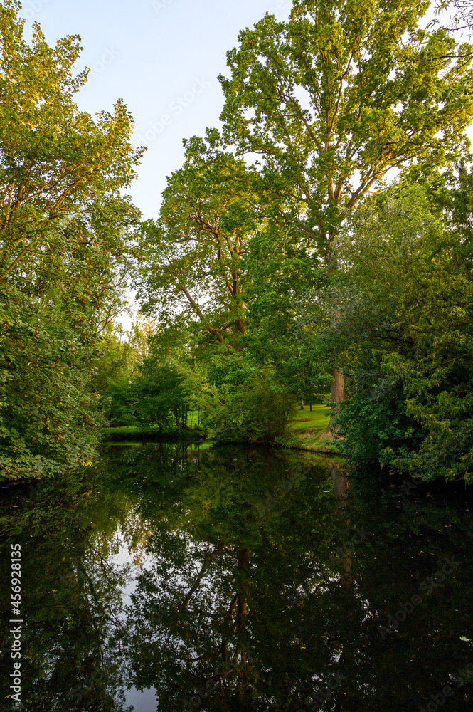 The Knoll, a small park in Hayes, Kent, UK. Reflections on the water of a small lake or pond with trees in The Knoll park. Hayes is in the Borough of Bromley in Greater London.
