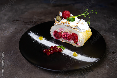 dessert sponge cake with raspberry filling and berries on plate