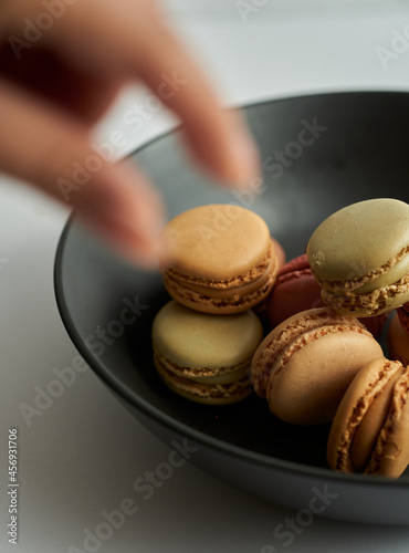 grabbing a macaron in a plate