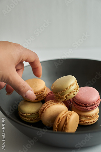 grabbing a macaron in a plate