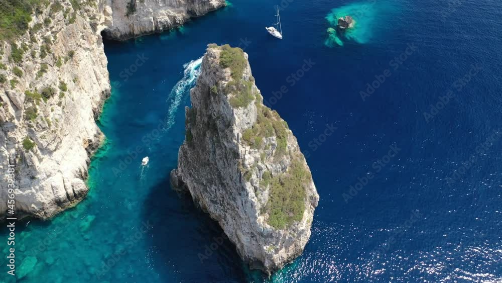 Aerial drone video of iconic Ortholithos and azure caves with deep turquoise sea where submarine Papanikolis was hiding during world war II, Paxos island, Ionian, Greece Aerial drone video of iconic Ortholithos and azure caves with deep turquoise sea where submarine Papanikolis was hiding during world war II, Paxos island, Ionian, Greece
