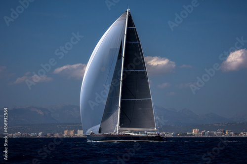 Maxi yacht with white genaker sailing in the bay photo