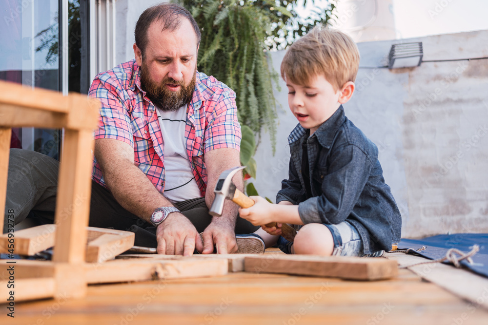 Father explaining to boy how to work with wood