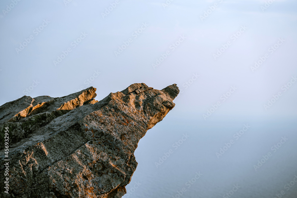 A sheer cliff above the sea against the sky. Minimalist landscape