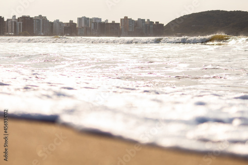 ESPUMA DAS ONDAS CHEGANDO NA AREIA DA PRAIA. photo