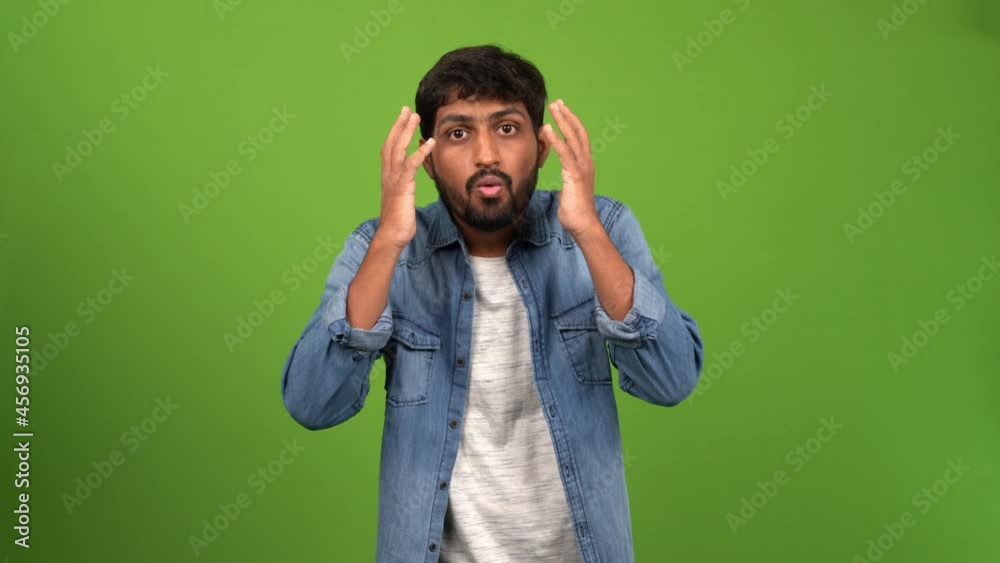 Asian man with his hands on his head looking tensed or worried. on green screen