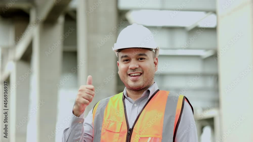 Asian engineer handsome man or architect looking construction with white safety helmet in construction site. Standing at highway concrete road site Showing thumbs up. Asian engineer handsome man or architect looking construction with white safety helmet in construction site. Standing at highway concrete road site Showing thumbs up.