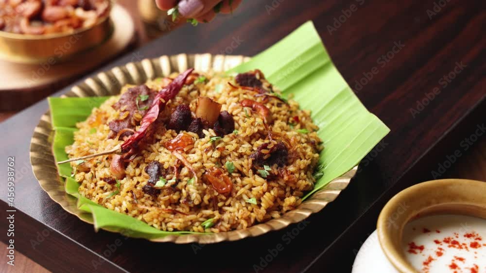 Hand Serving Mutton Gosht Biryani Spicy Indian Malabar lamb meat