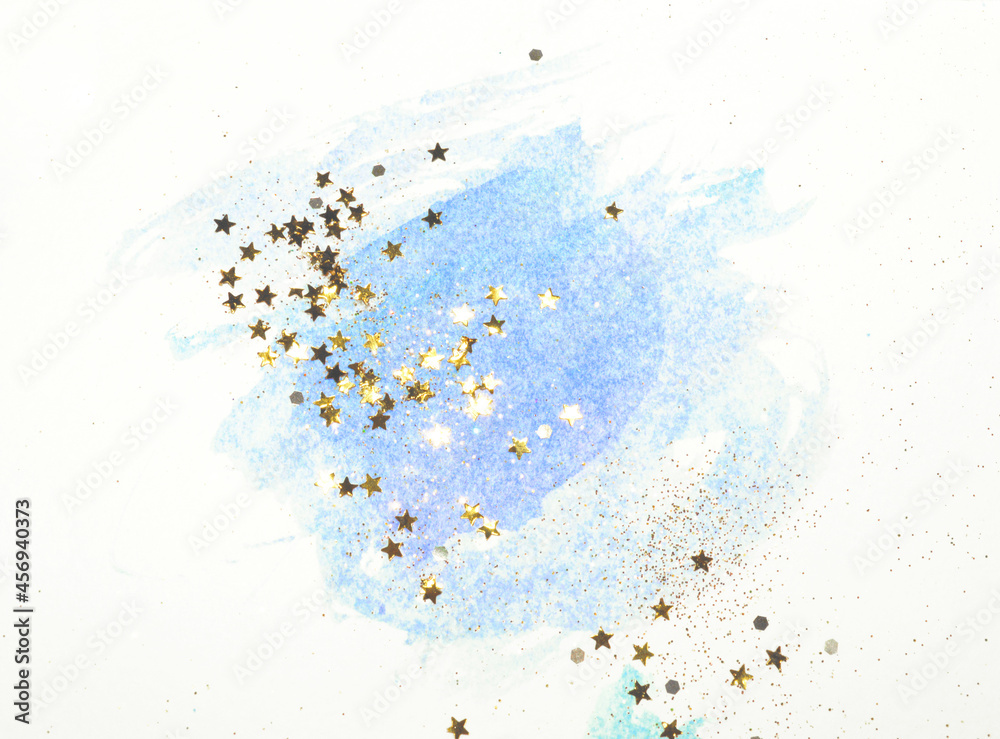 Golden glitter and glittering stars on abstract blue watercolor splash in vintage nostalgic colors