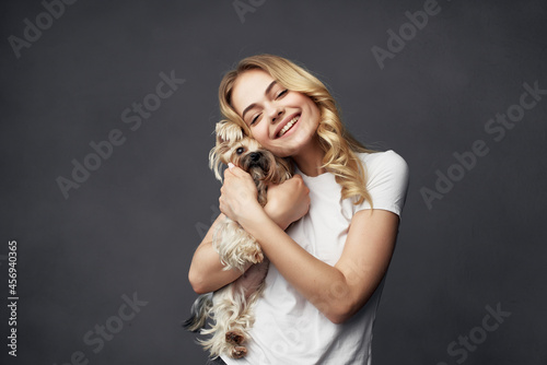 blonde with a small purebred dog joy smile dark background