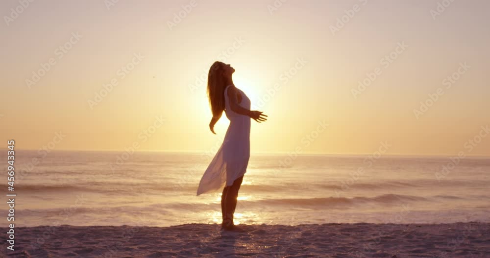 Free happy woman arms outstretched enjoying nature on beach at sunset face raised towards sky slow motion RED DRAGON