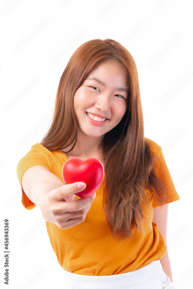 Portrait of smiling a beautiful Asian young woman holding red heart in hand on white background- Valentine day concept Portrait of smiling a beautiful Asian young woman holding red heart in hand on white background- Valentine day concept