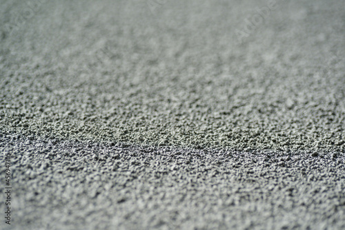 Macro texture details of brick wall roughcast painted grey. Shallow depth of field.