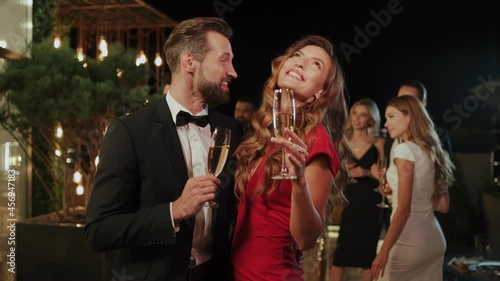 Beautiful young couple drinking champagne while spending time on luxury party 