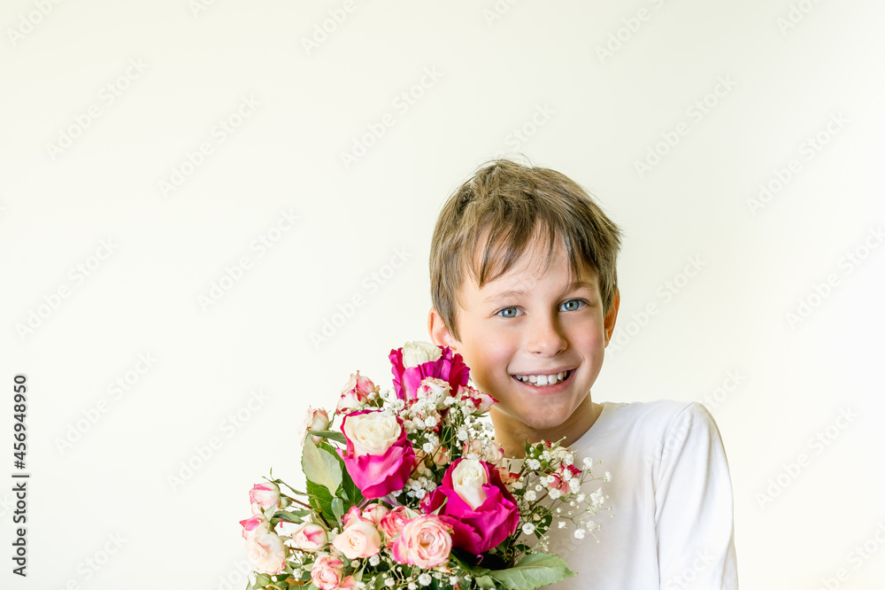 Eight year old caucasian boy laughing while handing a bouquet of flowers. Greeting card mockup with copy space Eight year old caucasian boy laughing while handing a bouquet of flowers. Greeting card mockup with copy space