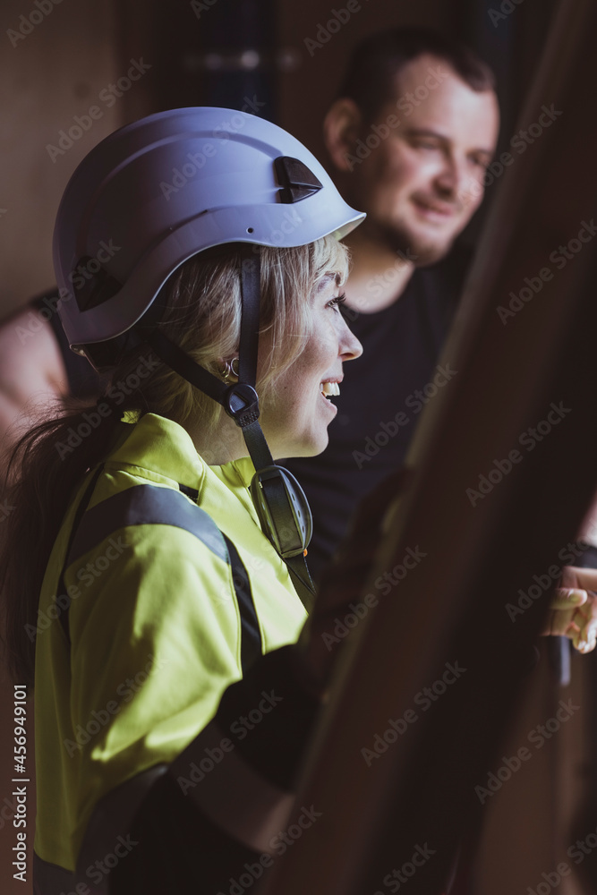 Smiling female building contractor discussing with male colleague at construction site