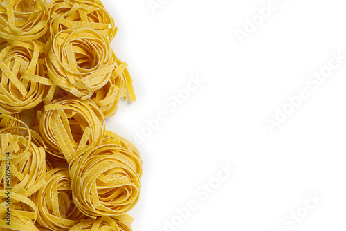 Fettuccine italian pasta isolated on white background. Raw tagliatelle nests isolated on white background. Traditional Italian pasta, flat lay copy space