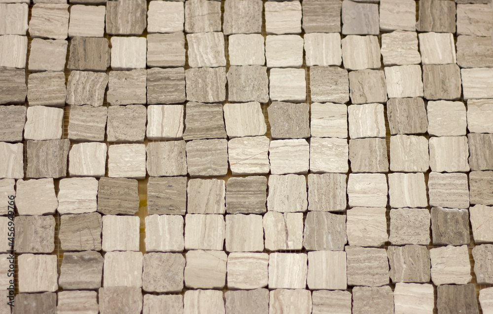 background mosaic of small stone blocks of uneven shape of gray color for the design of walls and floors in the interior close-up background mosaic of small stone blocks of uneven shape of gray color for the design of walls and floors in the interior close-up