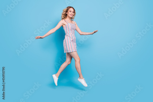 Full length body size photo woman running jumping high isolated pastel blue color background