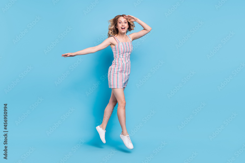 Full length body size photo woman jumping looking far hand near forehead isolated pastel blue color background