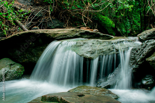 Fototapeta Naklejka Na Ścianę i Meble -  small waterfall with clear water amidst green nature.