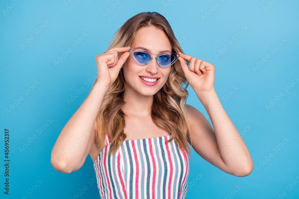 Photo portrait blonde woman wearing sunglass smiling happy isolated pastel blue color background Photo portrait blonde woman wearing sunglass smiling happy isolated pastel blue color background