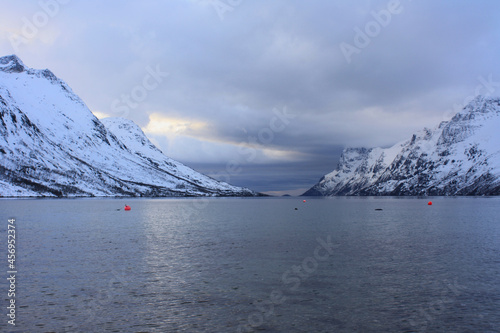 Snow-covered Norwegian fjord in winter, a cloudy day. photo