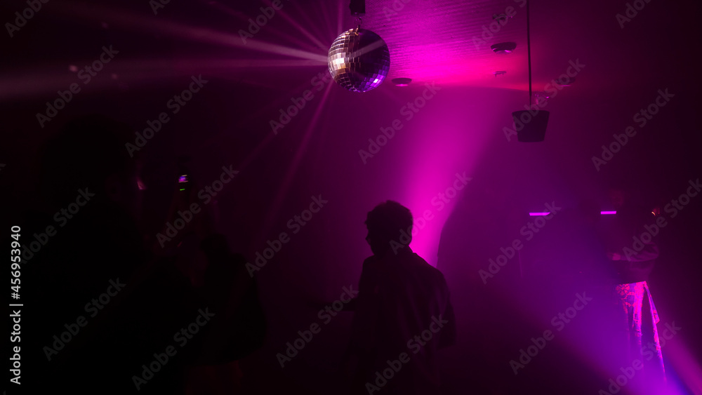 Party atmosphere with disco ball. Light beams reflecting from a disco ball. Nightlife concept. Space for text.