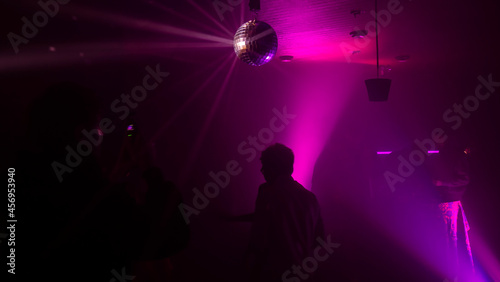 Party atmosphere with disco ball. Light beams reflecting from a disco ball. Nightlife concept. Space for text. © kalyanby