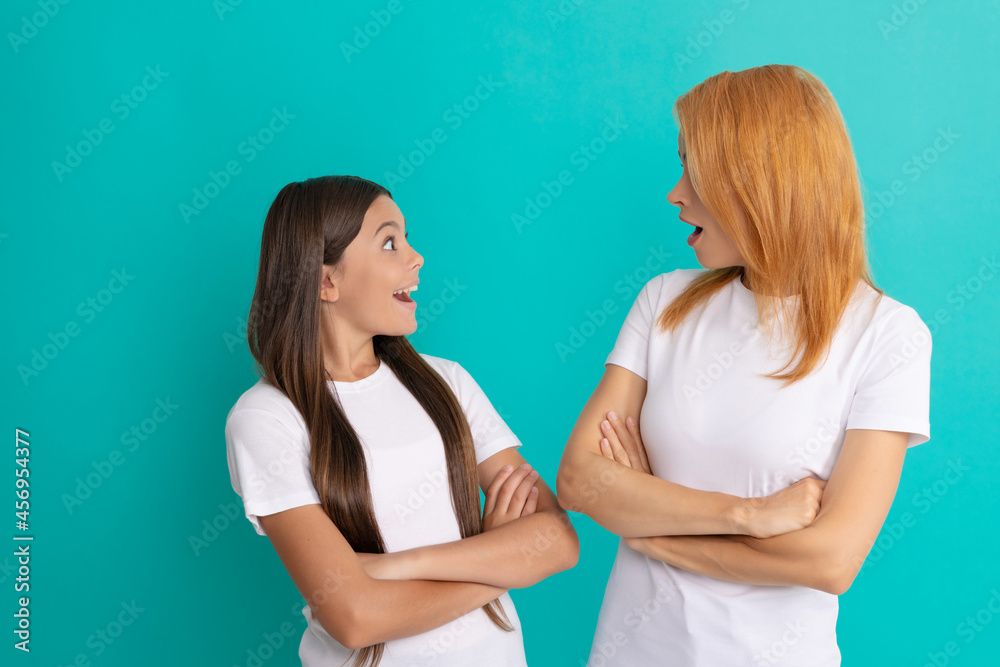 amazed mom and daughter with straight hair in white shirts crossed hands, amazement amazed mom and daughter with straight hair in white shirts crossed hands, amazement