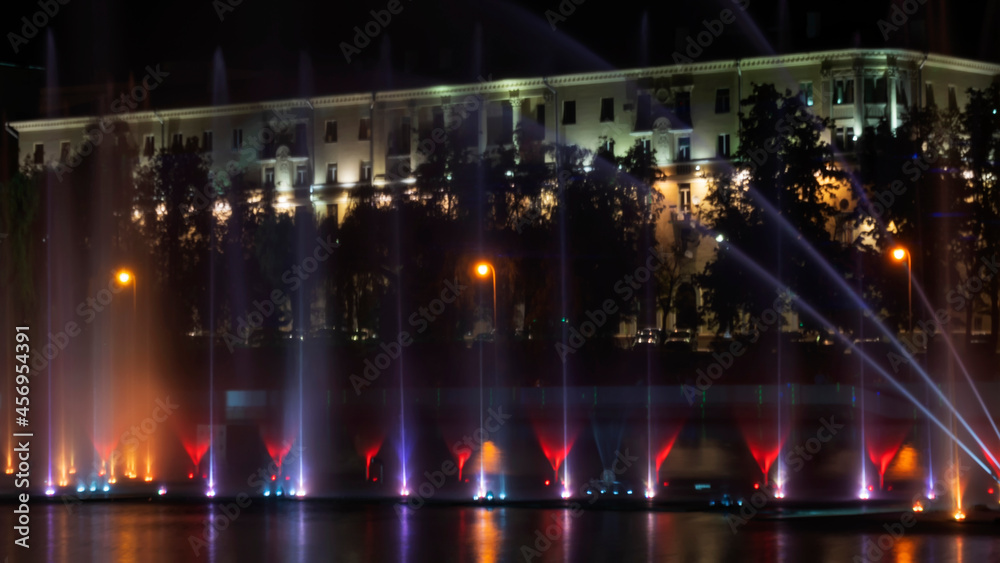 Multicolored musical fountain on a river at night. The fountain in the night from illumination. Long exposure.