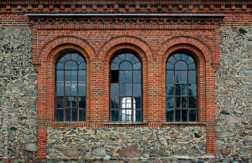 General view and close-up of architectural details of the former Evangelical church built in 1855 from field stone in the village of Rybno in warmia in Poland.
