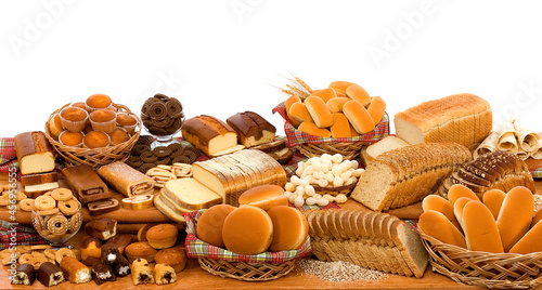 Mix de pães industrializados, bolos, rosquinhas, pães especiais tudo na mesa em fundo branco para recorte. photo