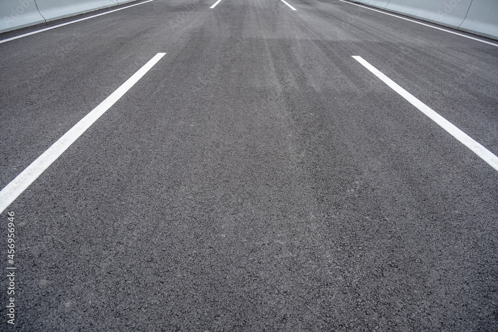 Empty asphalt highway road with city skyline.