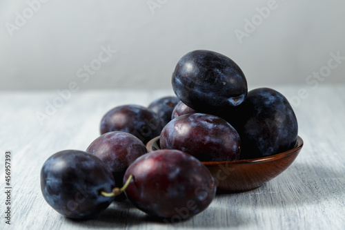 Fresh plums. Fruits. On a white wooden background. Copy space.