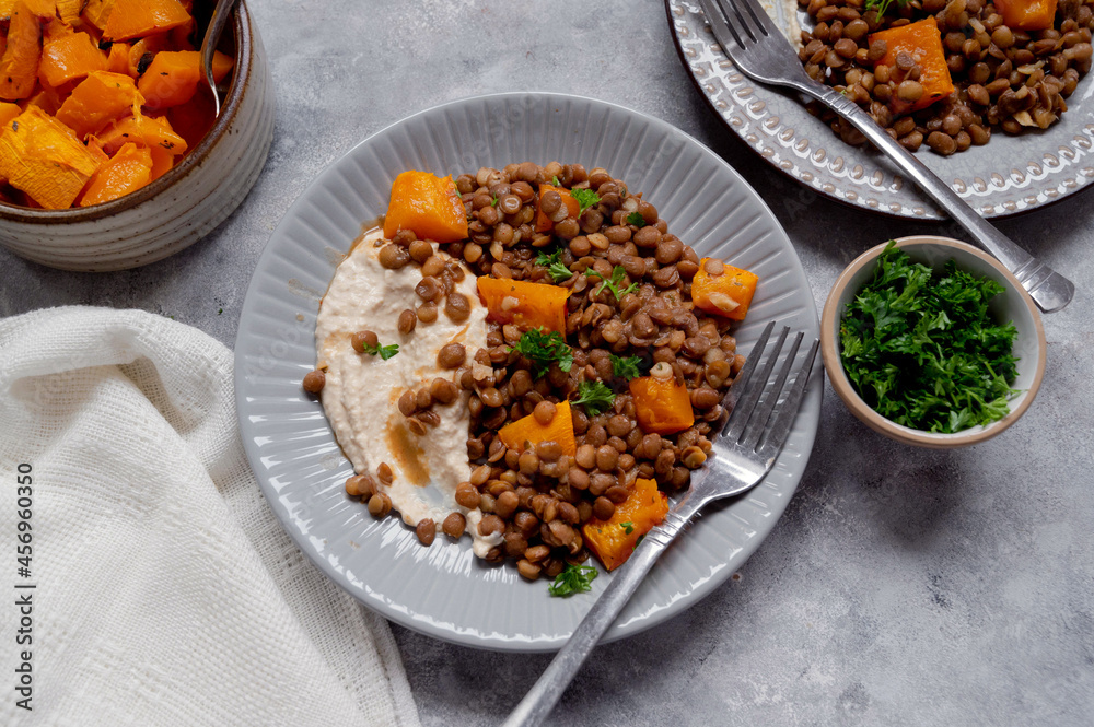 Fototapeta premium Vegan healthy food. Lentils and butternut squash with houmus and green herbs, clean eating concept