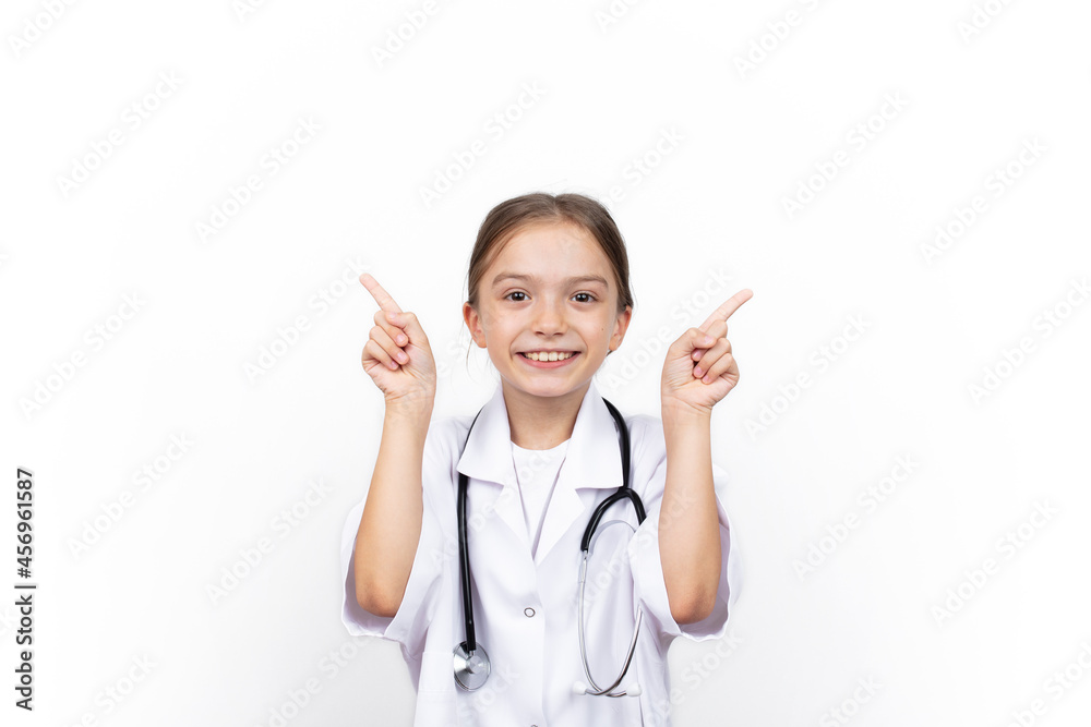 Smiling happy child girl in doctor's coat pointing at white background
Smiling happy child girl in doctor's coat pointing at white background