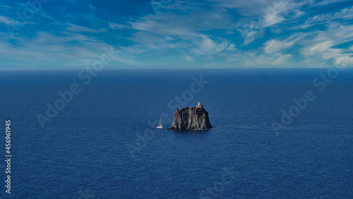 Beautiful view of Strombolicchio lighthouse in the middle of the sea, Italy photo