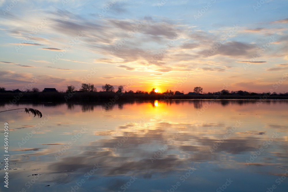 Beautiful sunset perfectly reflected in the waters of the river.