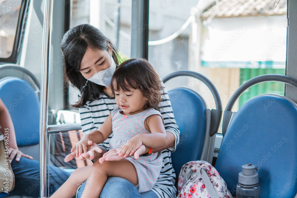 Fototapeta premium happy asian mother taking her daughter riding public transport