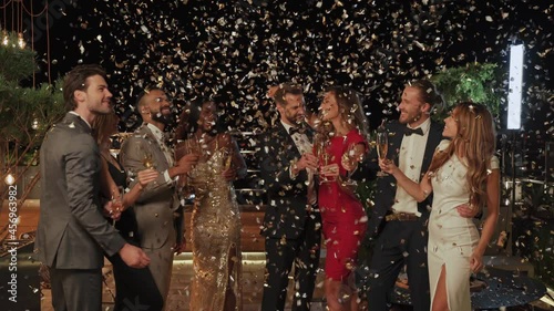 Group of happy people dancing and having fun together with confetti